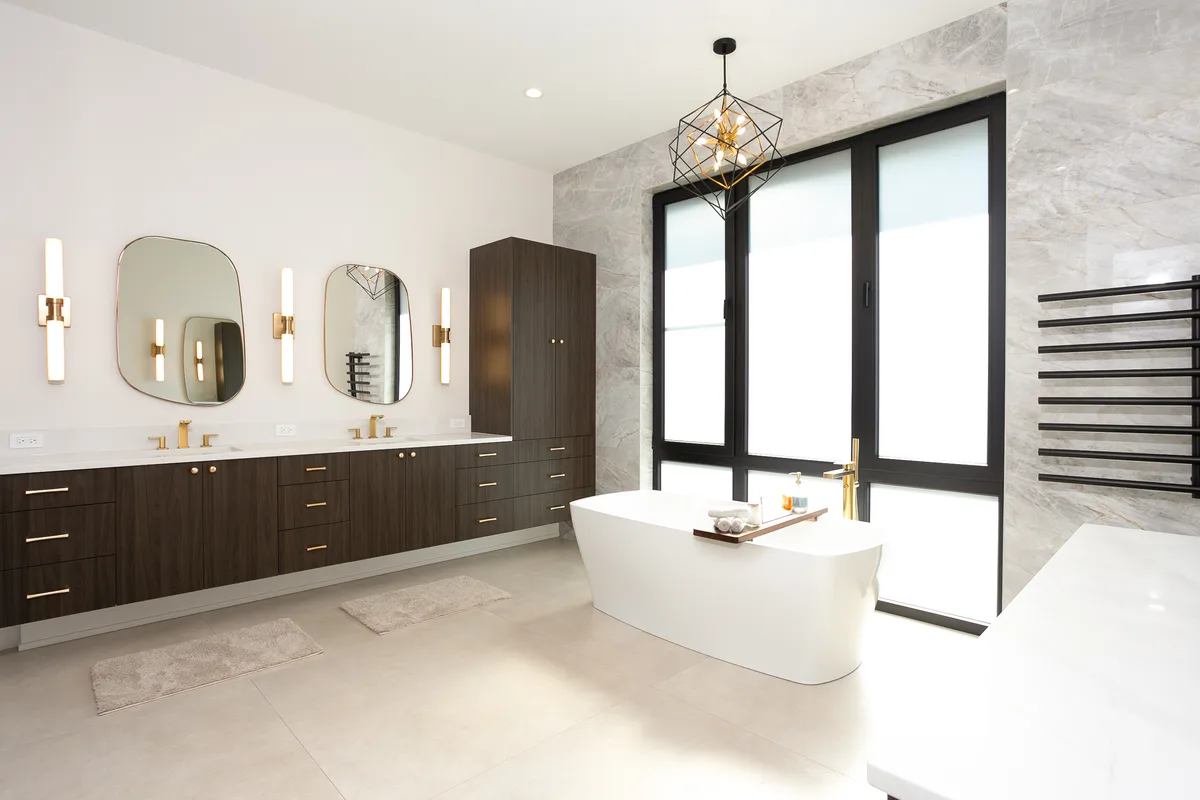 Primary bathroom with a freestanding tub set against floor-to-ceiling black-framed windows and a full-height marble slab wall - Lemont IL