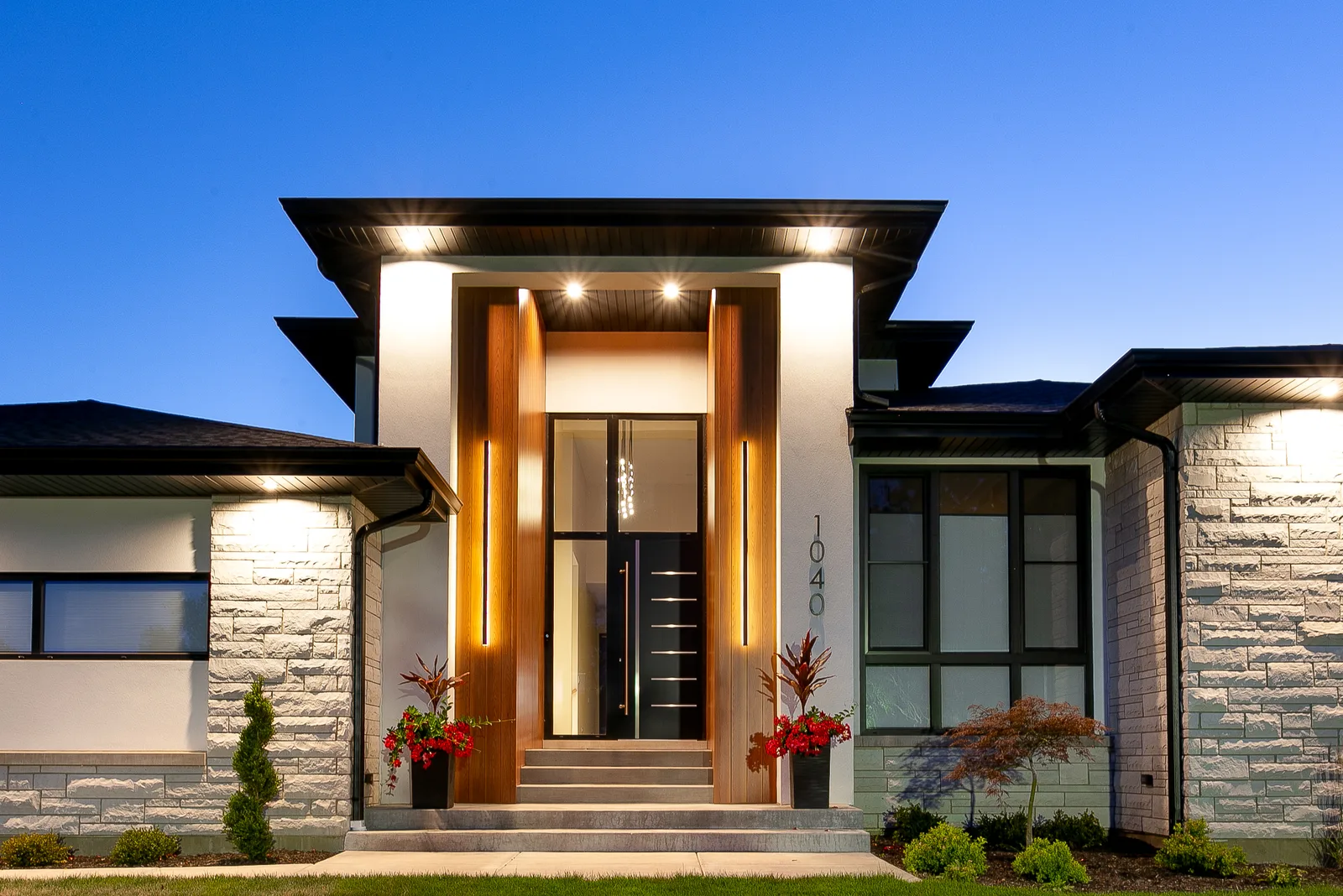 Warm-lit wood front entry under a deep overhang at dusk - custom home, Lemont IL