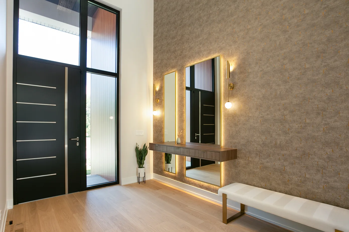Entry foyer with a floating walnut-wood console and backlit brass-framed mirror - custom home, Lemont IL