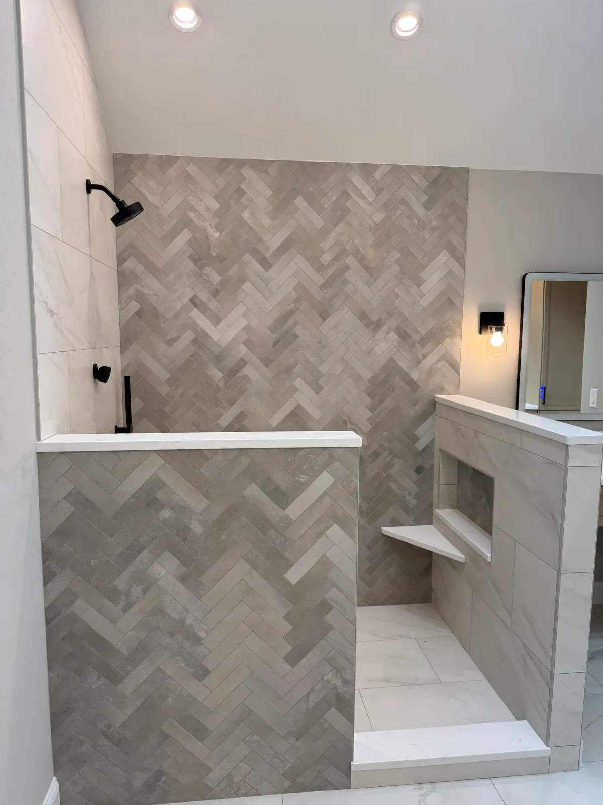 Open walk-in shower with a full-height herringbone accent wall and a wall-mounted shower head in matte black - primary bath remodel, Mokena IL