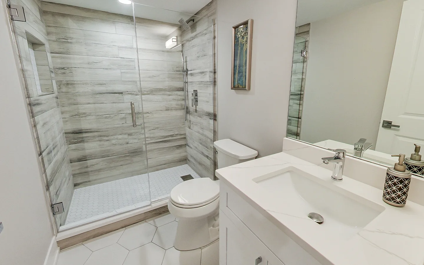 Walk-in stone shower with frameless glass by Luxe Development