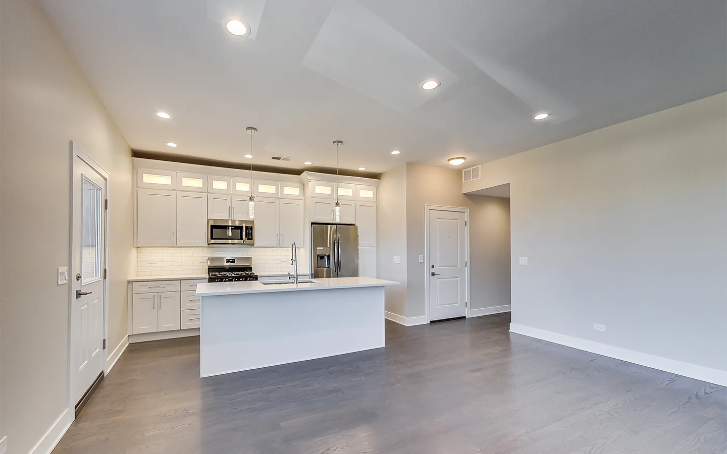 Quartz-topped island in a white shaker kitchen by Luxe Development